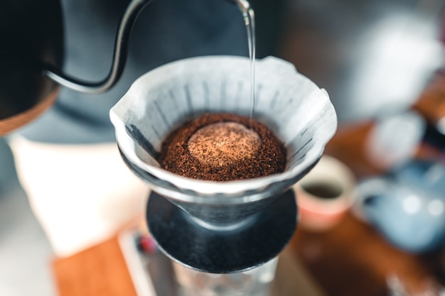 Professional barista preparing coffee pour over coffee maker and drip kettle