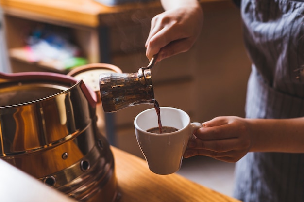 Professional barista serving traditional turkish coffee in cafeteria