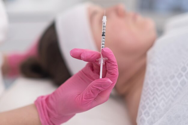 Professional beautician holding syringe to smoothing wrinkles with injections mesotherapy