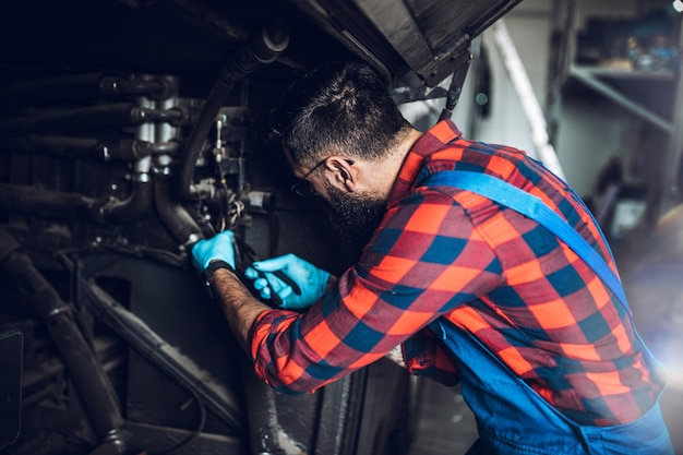 Professional bus mechanic working in vehicle repair service.