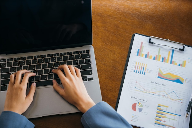 Professional business woman working on laptop computer with chart graphs and calculator