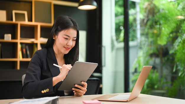 Professional businesswoman writing her business plan on digital tablet