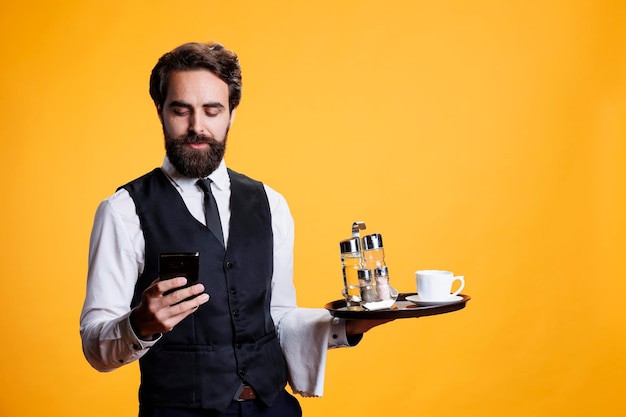 Photo professional butler checks smartphone