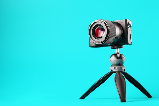 Professional camera on a tripod, on a blue background. Record videos and photos for your blog or report.