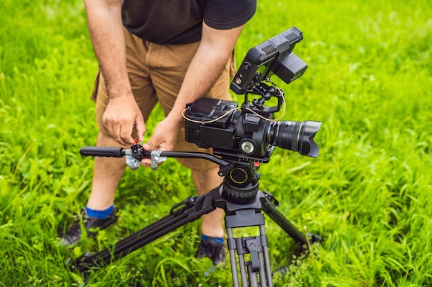 A professional cameraman prepares a camera and a tripod before shooting