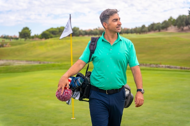 A professional Caucasian golf player on a golf course next to the flag on the green