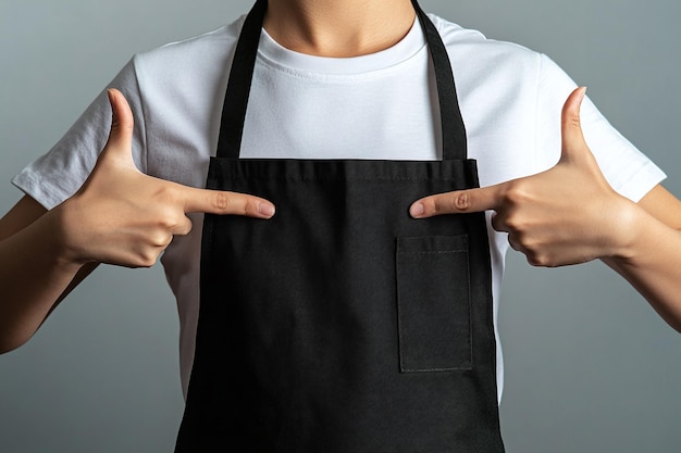 Photo professional chef in black apron pointing up ideal mockup for restaurant uniform culinary branding