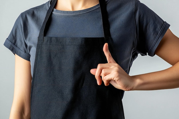 Photo professional chef in black apron pointing up ideal mockup for restaurant uniform culinary branding