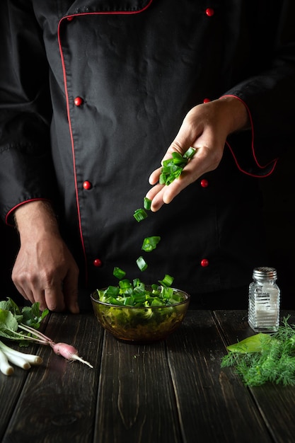 Professional chef prepares food from fresh Lettuce in the kitchen