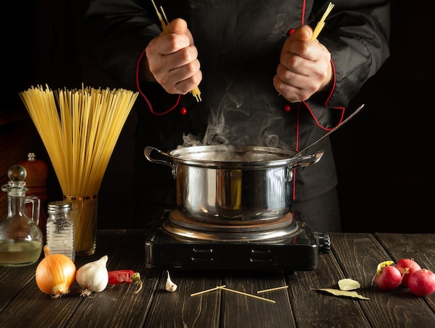 Professional chef prepares Italian pasta The cook keeps spaghetti in the kitchen