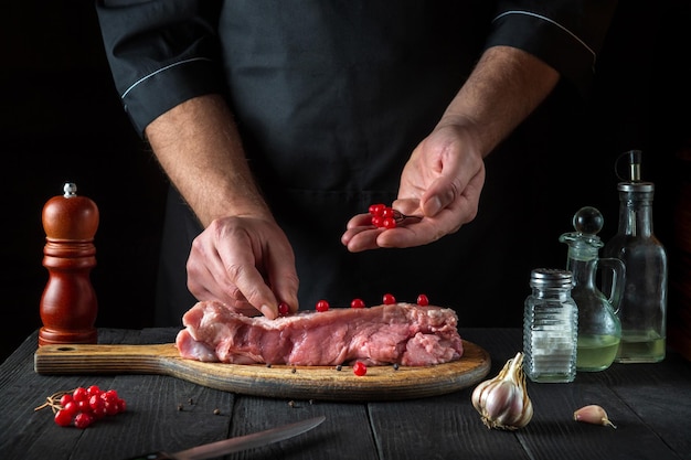 Professional chef prepares raw veal meat