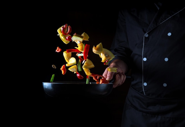 Professional chef prepares vegetables in frying pan Cooking healthy vegetarian food and meal