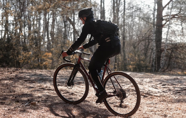 Professional cyclist rides on a sandy road in the forest Activity and sports