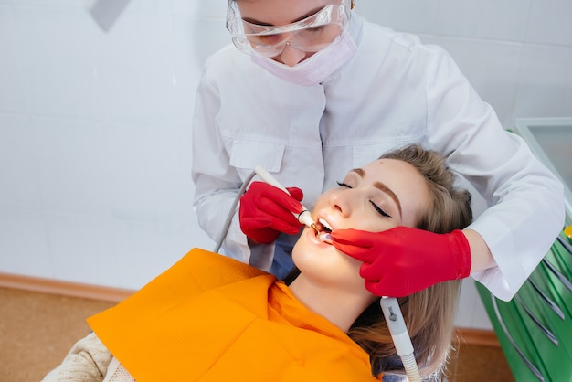 A professional dentist performs treatment and examination of the patient's oral cavity in close-up. Dentistry