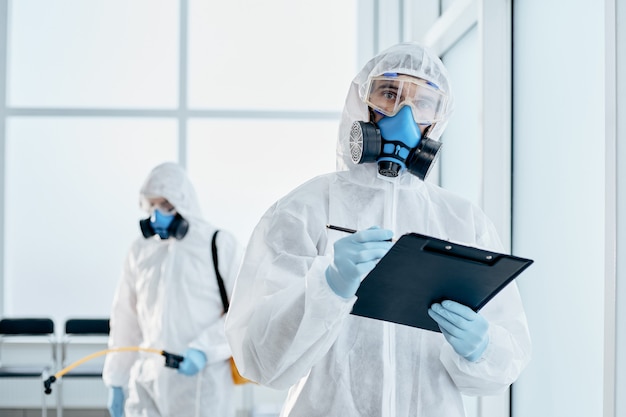 Professional disinfector taking notes on the clipboard