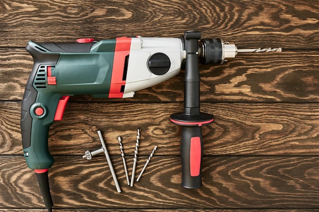 Professional electric drillperforator with handle on wooden background