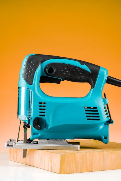 Professional electric Jigsaw saw with round handle isolated on yellow background.