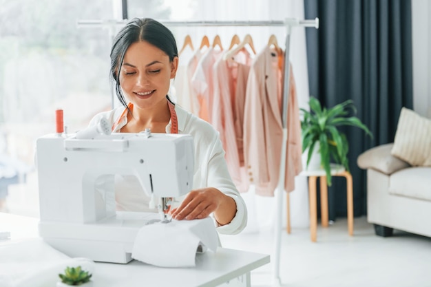 Professional equipment Seamstress is in her office that is with different clothes