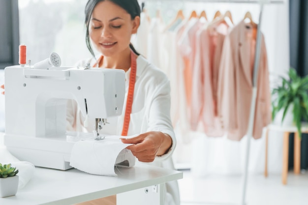 Professional equipment Seamstress is in her office that is with different clothes