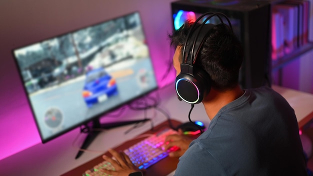 Professional gamers in headphone playing online car racing game at home