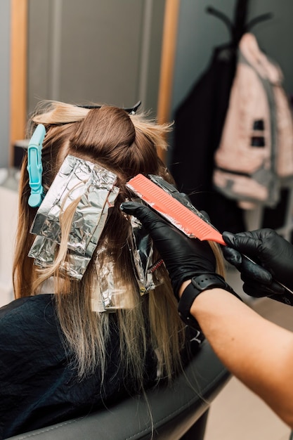 A professional hairdresser applies dye to a client's hair Hair coloring