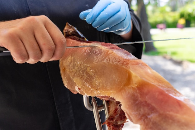 Professional ham cutter cutting an Iberian ham in a celebration event wedding