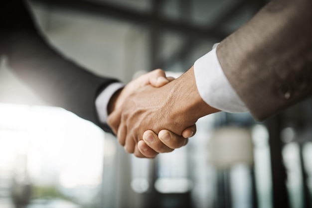 A professional handshake after an interview meeting for a successful company in a modern corporate office Formal executive businessman shaking customers hand after a contract deal agreement together