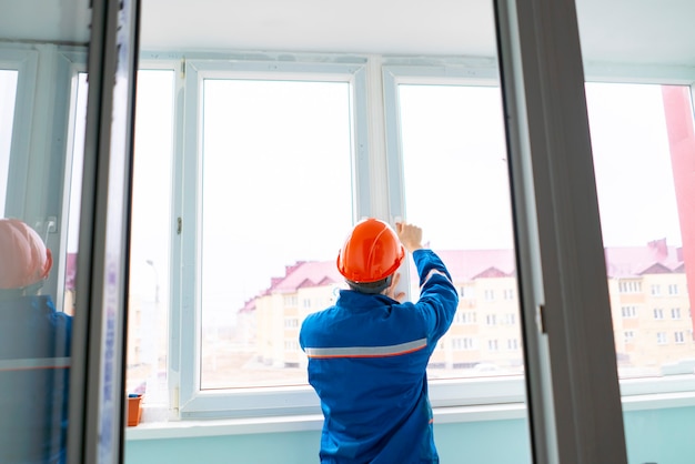 A professional handyman worker install and adjust window in the house