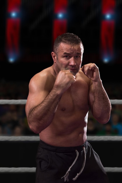 professional kickboxer with hands in martial arts position training for the fight in the training ring