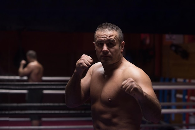 professional kickboxer with hands in martial arts position training for the fight in the training ring