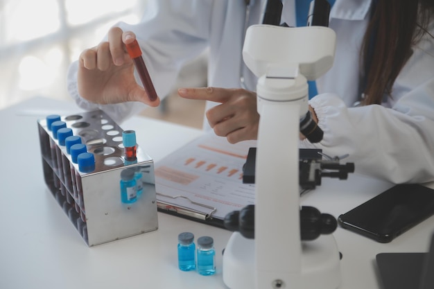 Professional lab Amazing longhaired medical worker wearing uniform while using microscope during research