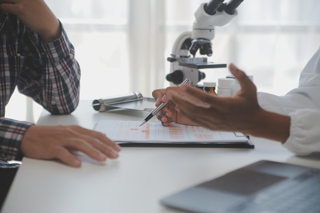 Professional lab Amazing longhaired medical worker wearing uniform while using microscope during research