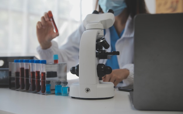 Professional lab Amazing longhaired medical worker wearing uniform while using microscope during research