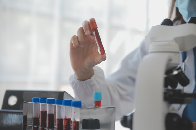 Professional lab Amazing longhaired medical worker wearing uniform while using microscope during research