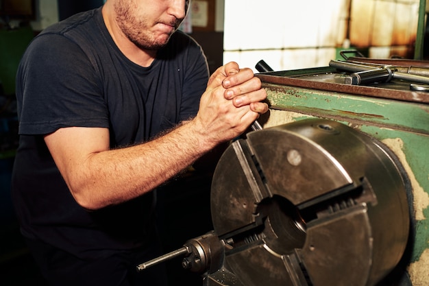 Professional machinist : man operating lathe grinding machine