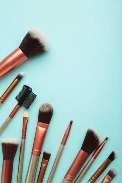 Professional make-up brushes on blue background. Vertical photo. Top view