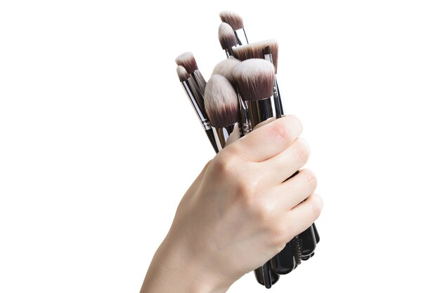 Professional make-up brushes cosmetic in female hand beautician isolated on white background