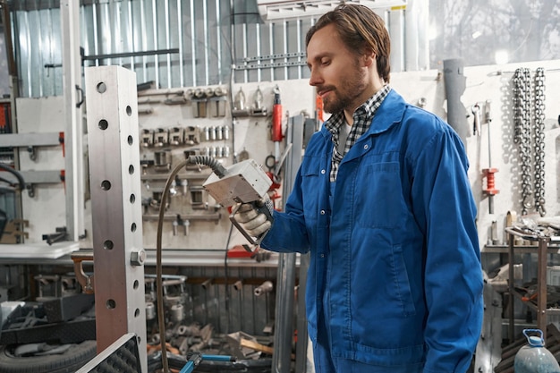 Professional man holding special tool for auto repair