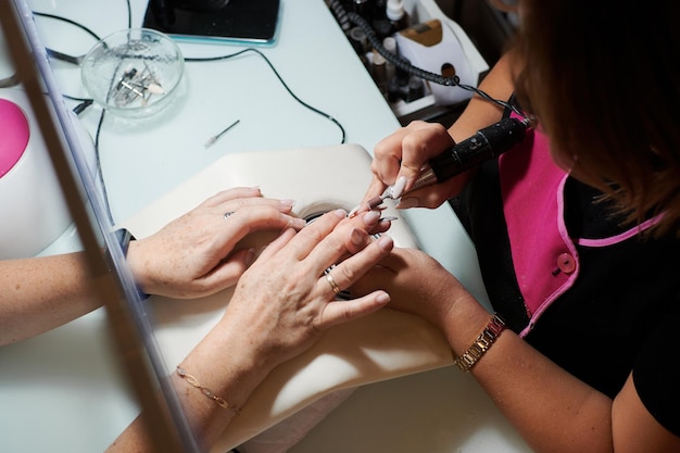 Professional manicurist fixes and beautifies a client's nails