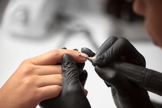 Professional master manicurist working on client fingernails