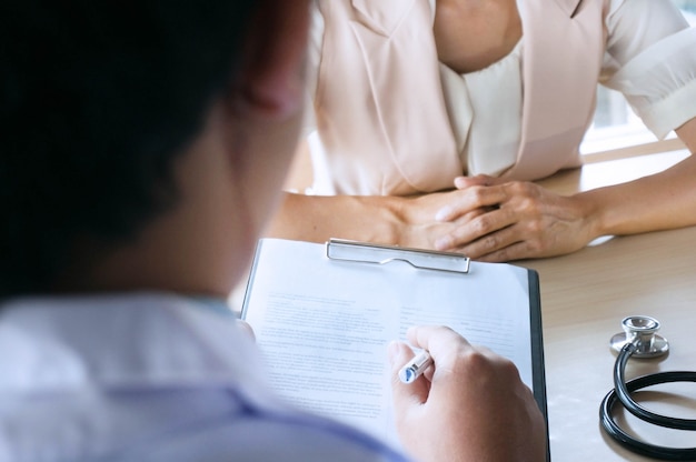 Professional medical doctor in white uniform gown coat interview consulting patient