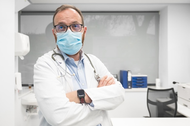 Professional medical doctor working in hospital office in protective face mask