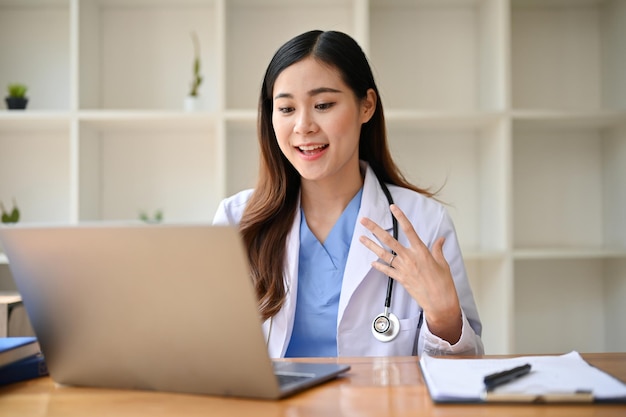 Professional millennial Asian female doctor is having online medical counseling with her patient