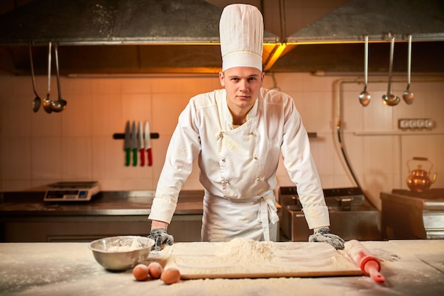 Professional pastry chef prepares dough with flour in a professional kitchen to make bread Italian pasta or pizza Baking food concept