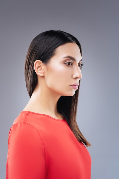 Professional photo. Smart calm unemotional woman standing with her back straight while being photographed for the driving license