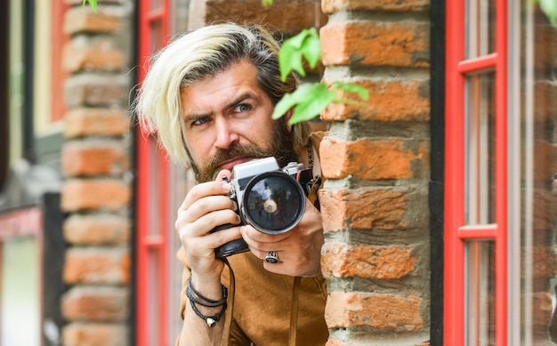 Professional photographer use vintage camera Photography business Bearded man hipster take photo Modern business Journalist reporter Brutal stylish man with retro camera Old technology