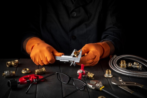 A professional plumber measures the diameter of a fitting with a caliper