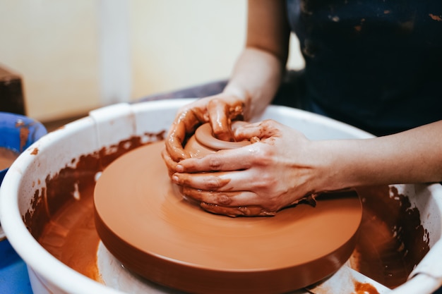 Professional potter works on a pottery wheel