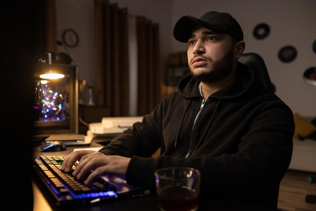 A professional programmer sits late at night at a computer with a light on fills out