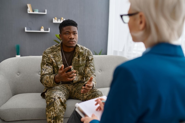 Professional psychologist giving advice to military patient